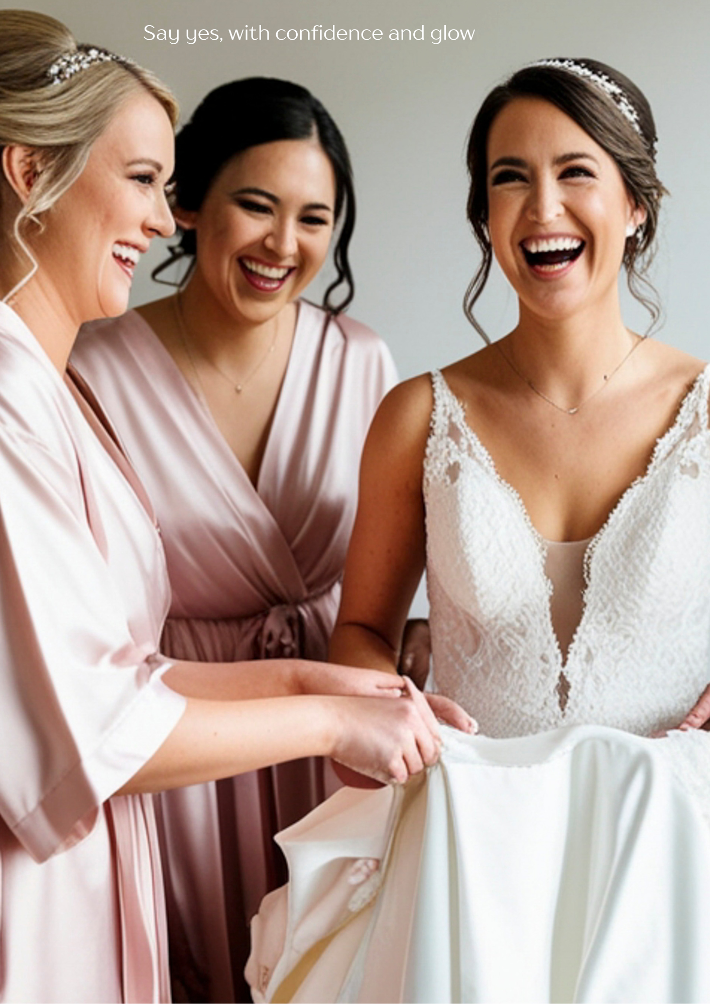 A joyful bride laughing with two members of her bridal party